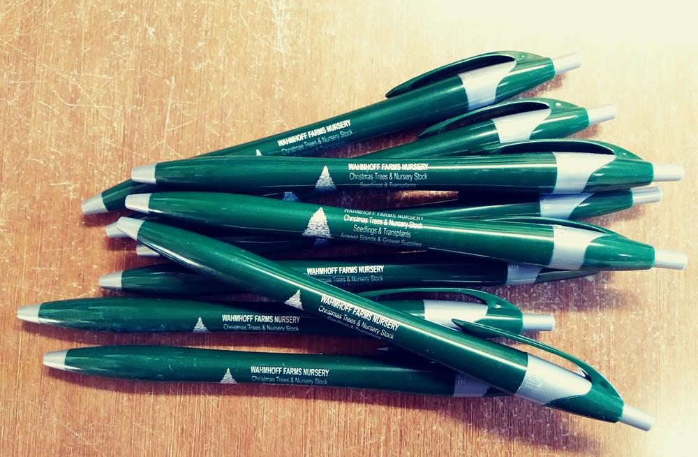 a group of green pens on a wood surface