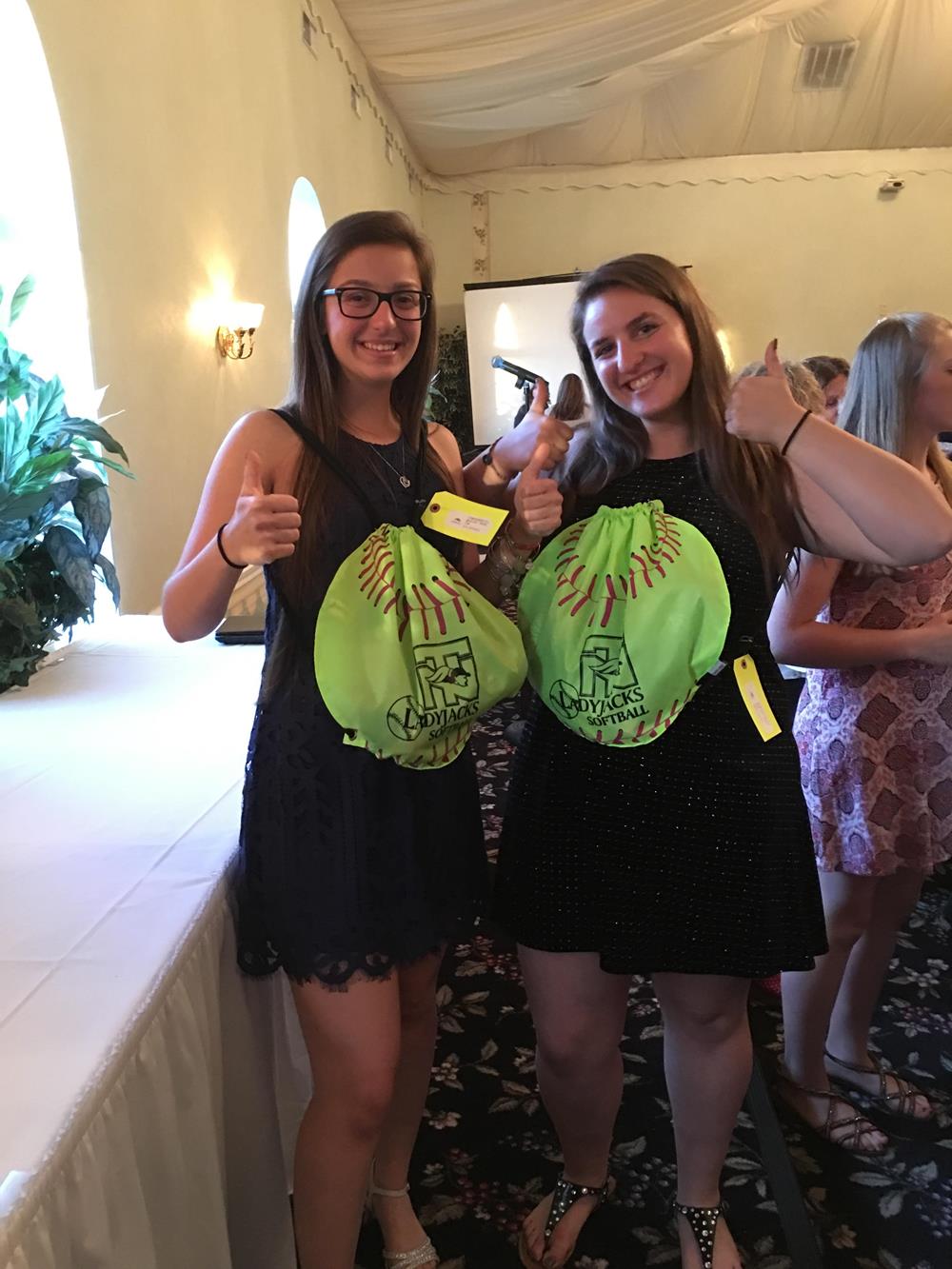 two women holding up their thumbs