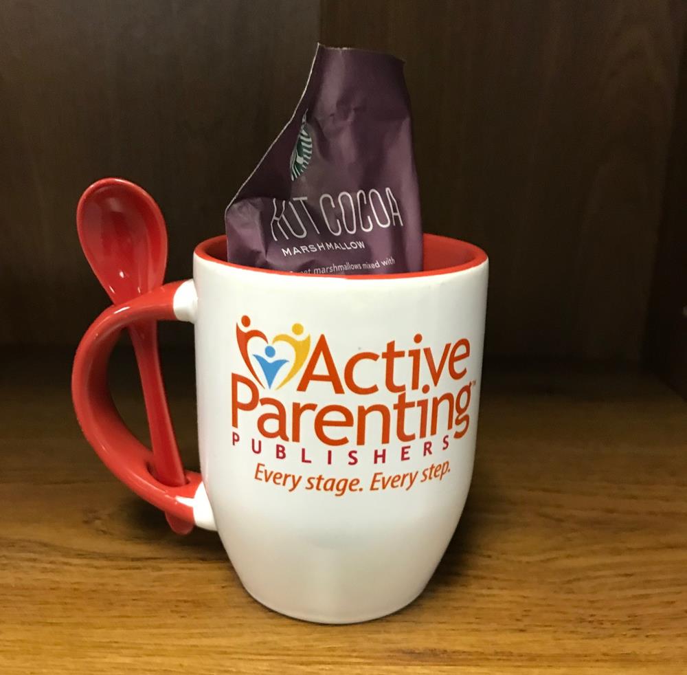 a mug with a spoon and a packet inside