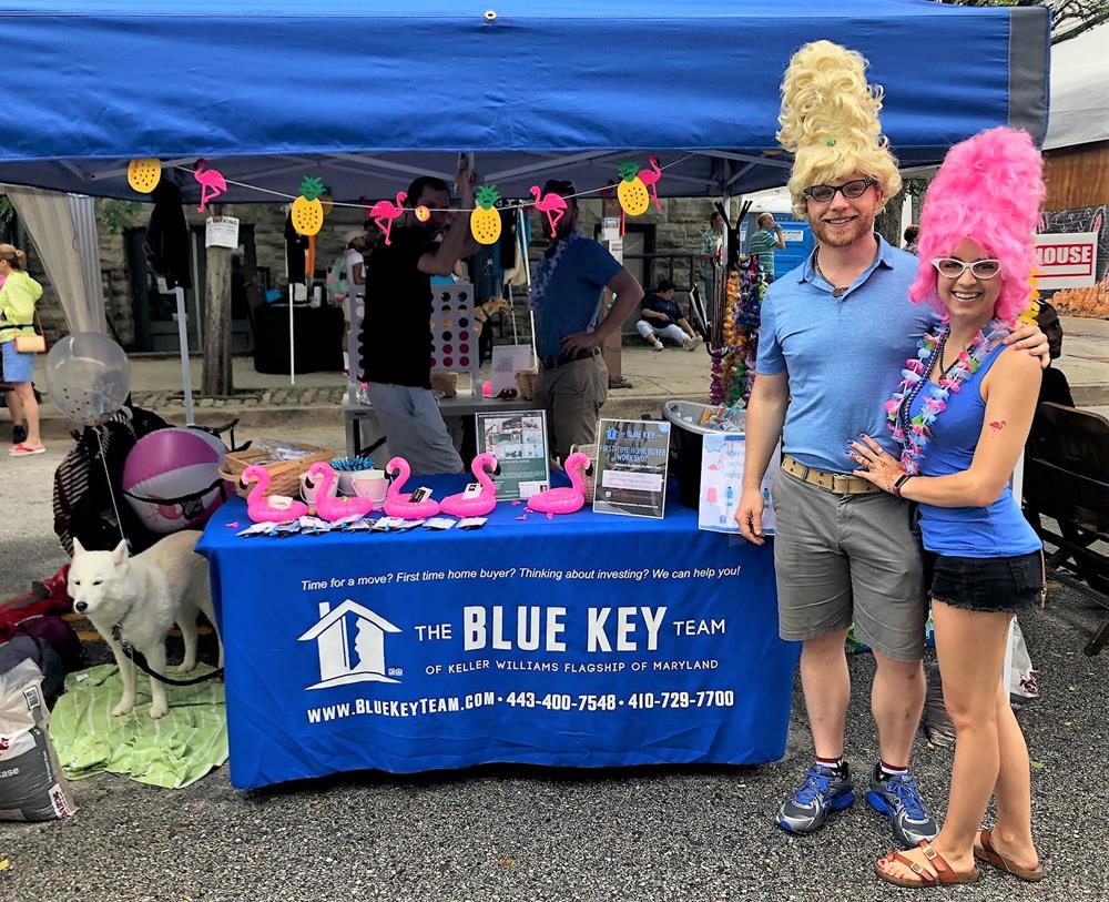 Customer photo from Callai of our Serged Closed-Back Fitted Table Cover - 6', a man and woman standing next to a table with pink wigs