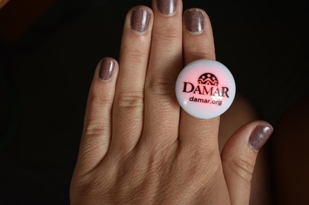 Customer photo from Rachel of our LED Glow Ring - Multicolor, a hand with a round white object on it