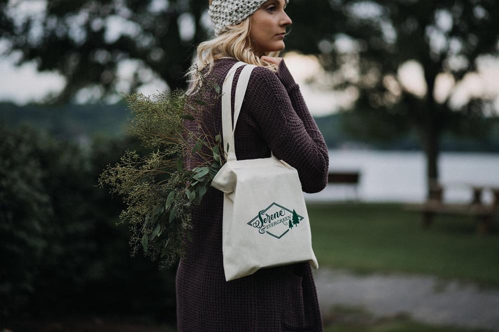 a woman with a bag and a plant on her shoulder
