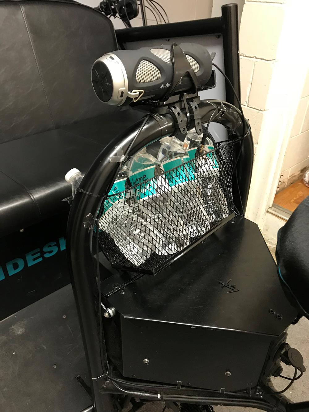 Customer photo from Bradley of our Water Bottle Label - 2" x 8", a black and silver object with a black mesh bag on a black surface