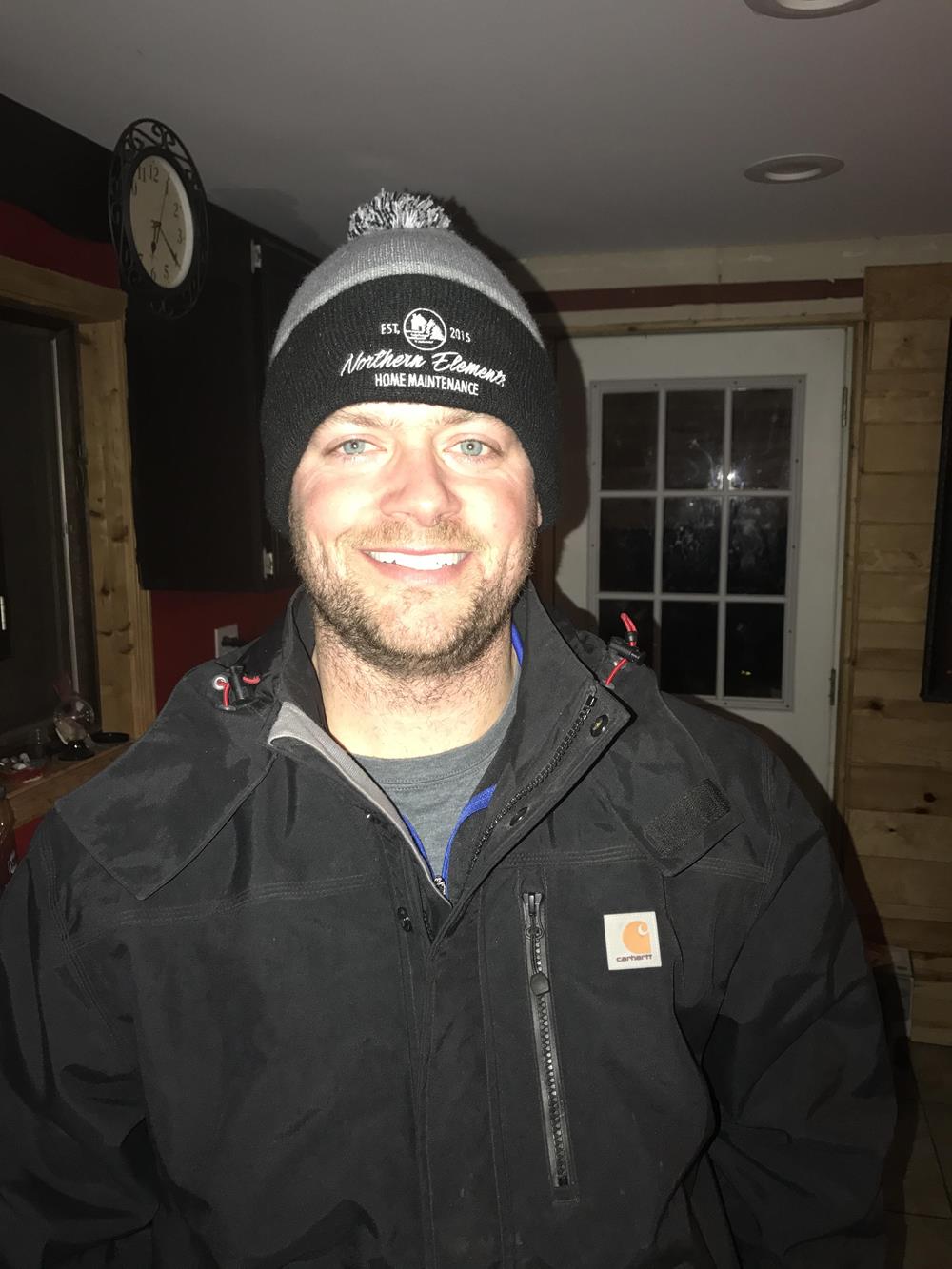 Customer photo from Jacqueline of our Tri-Tone Striped Pom Pom Cuff Beanie, a man wearing a beanie and a jacket