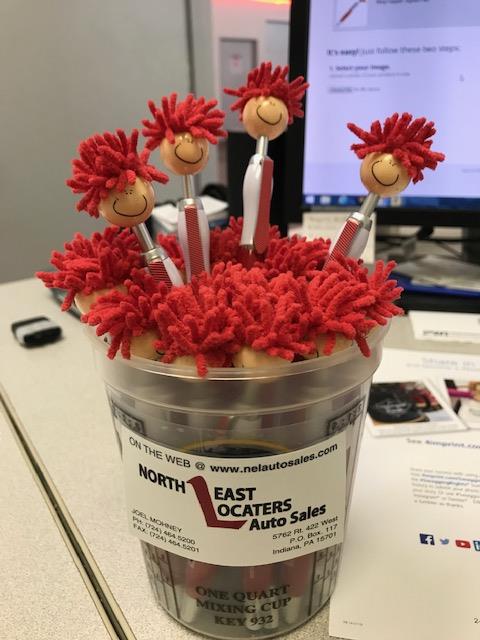 a bucket of pens with red hair