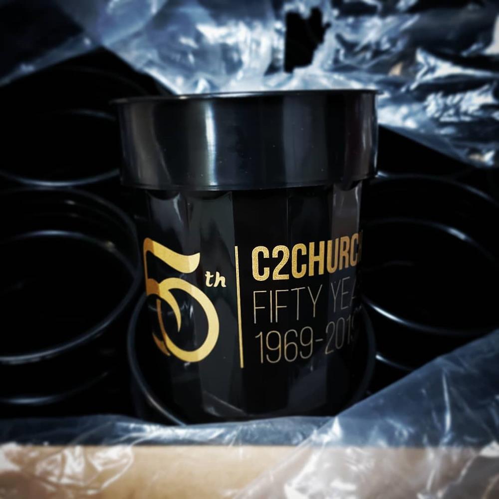 Customer photo from Megan of our Stadium Cup - 16 oz - Fluted, a black container with gold text and numbers