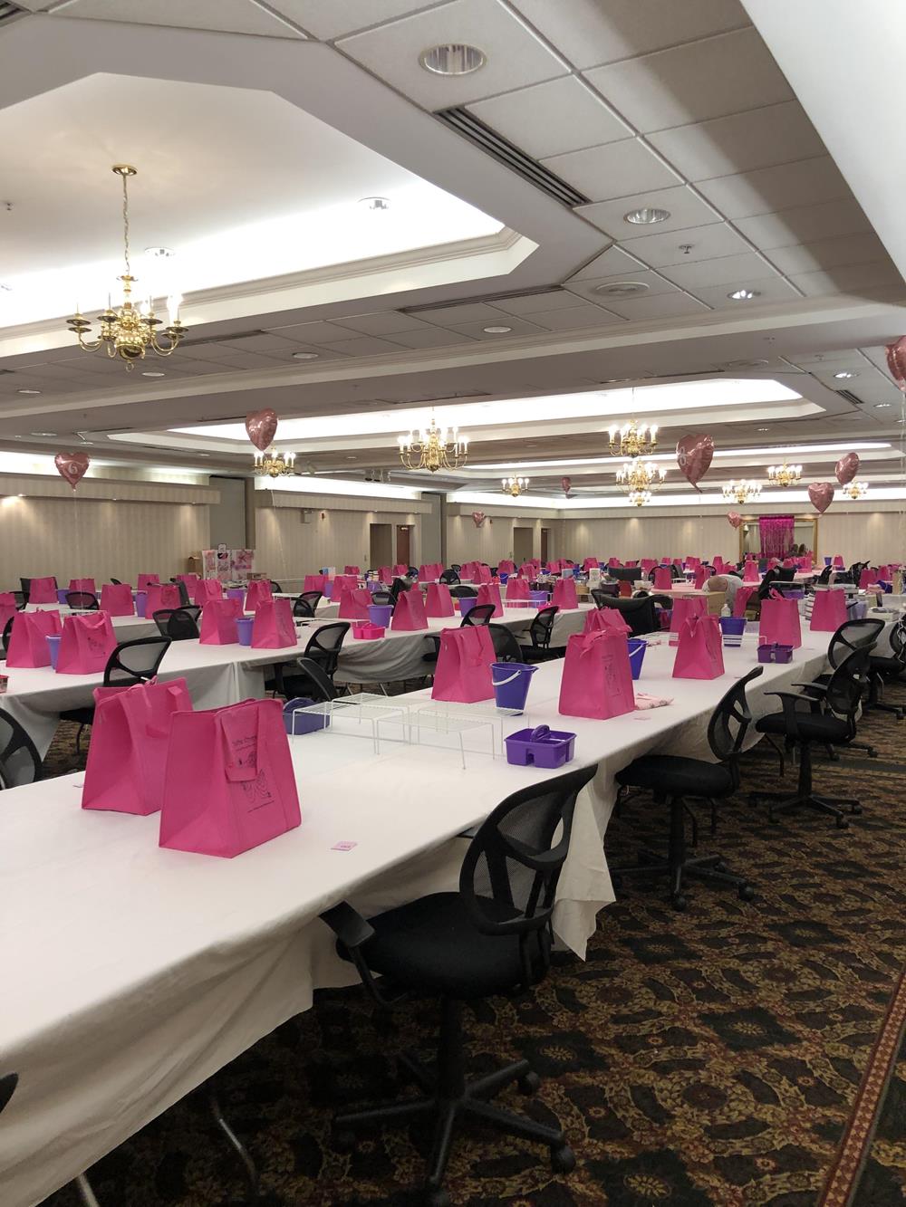 a room with tables and chairs with pink bags