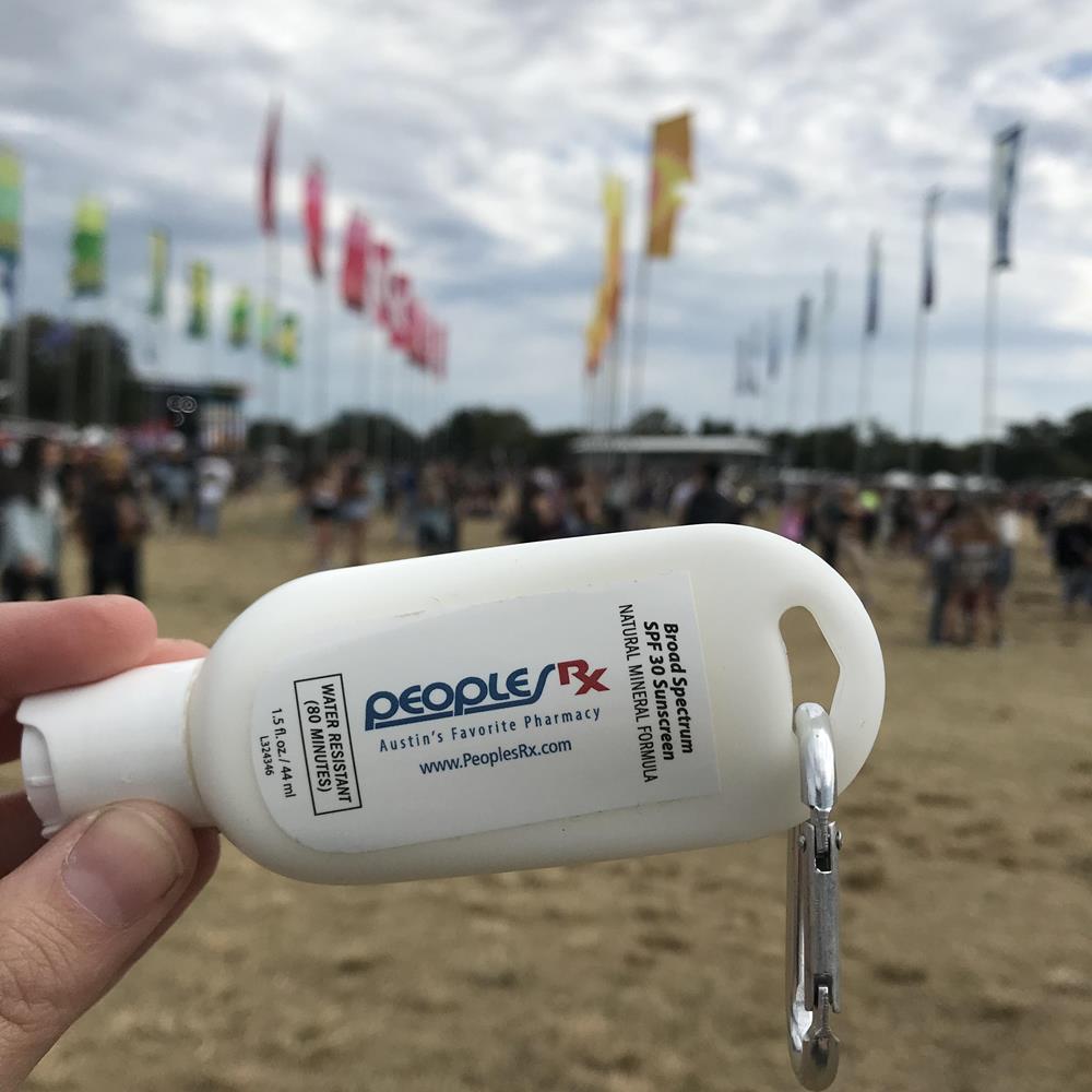 a hand holding a white bottle with a key chain