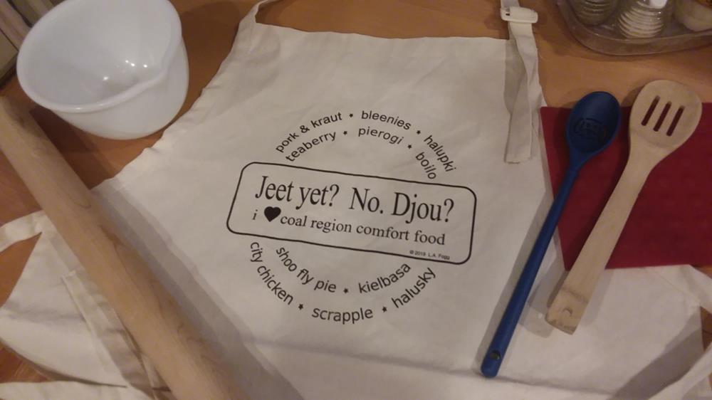 Customer photo from Lori of our Chef's Apron, a white bag with black text on it