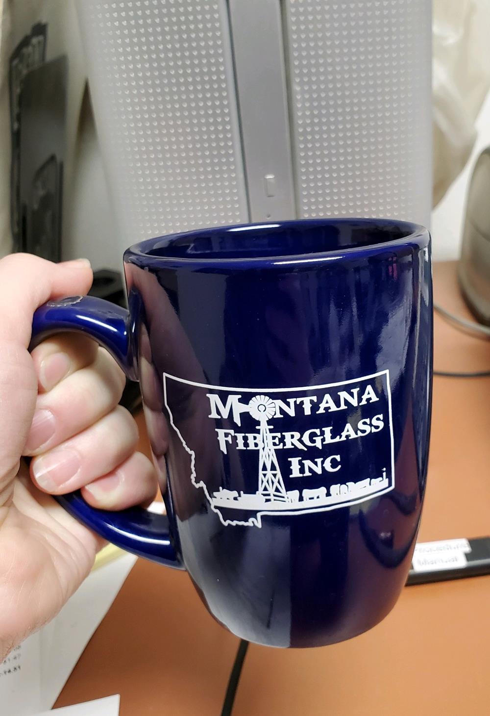 Customer photo from Lacey of our Challenger Coffee Mug - Colors - 11 oz., a hand holding a blue coffee mug