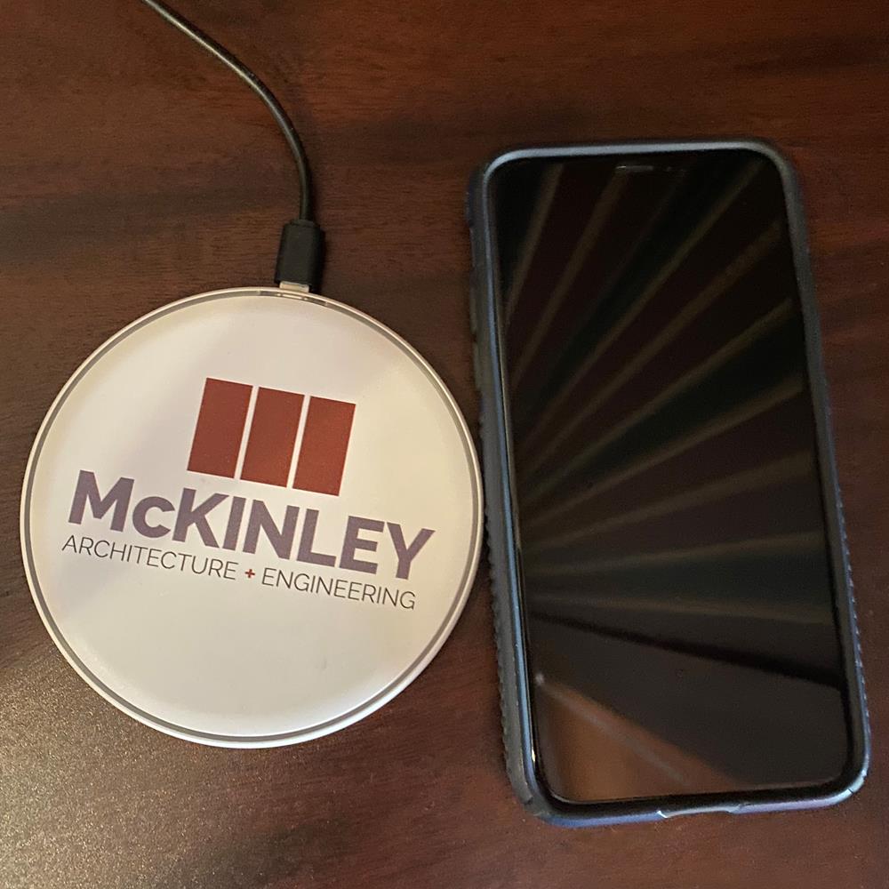 Customer photo from David of our Slim Wireless Charging Pad - Full Color, a phone and a circular object on a table