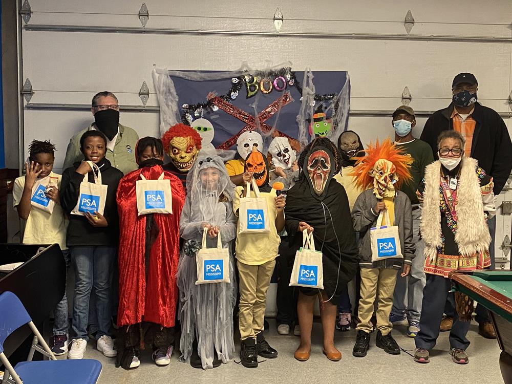 Customer photo from Calvin of our Cotton Sheeting Natural Economy Tote - 9-1/2" x 9", a group of people wearing masks and holding bags