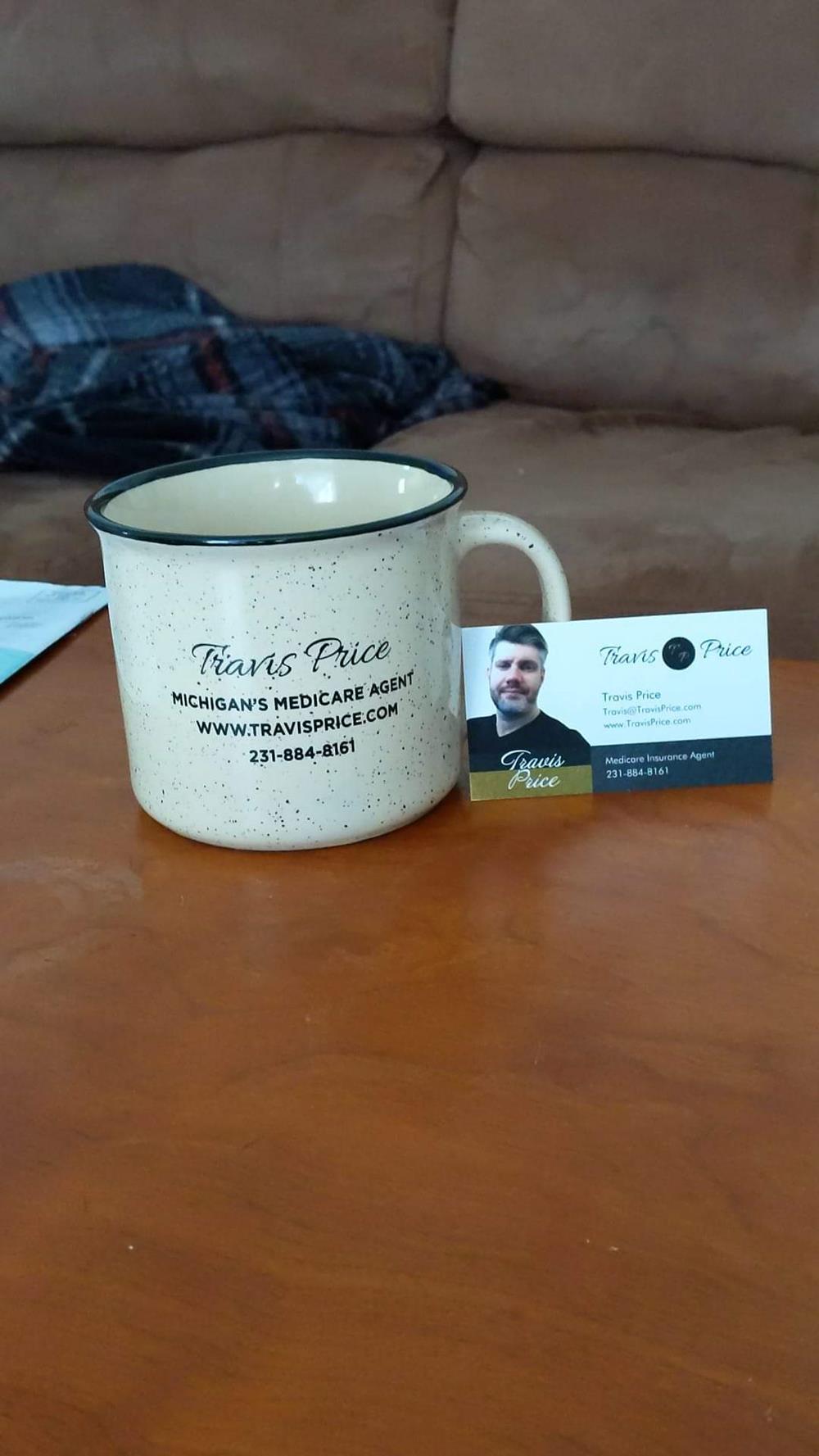 a white mug with black text and a business card on a table