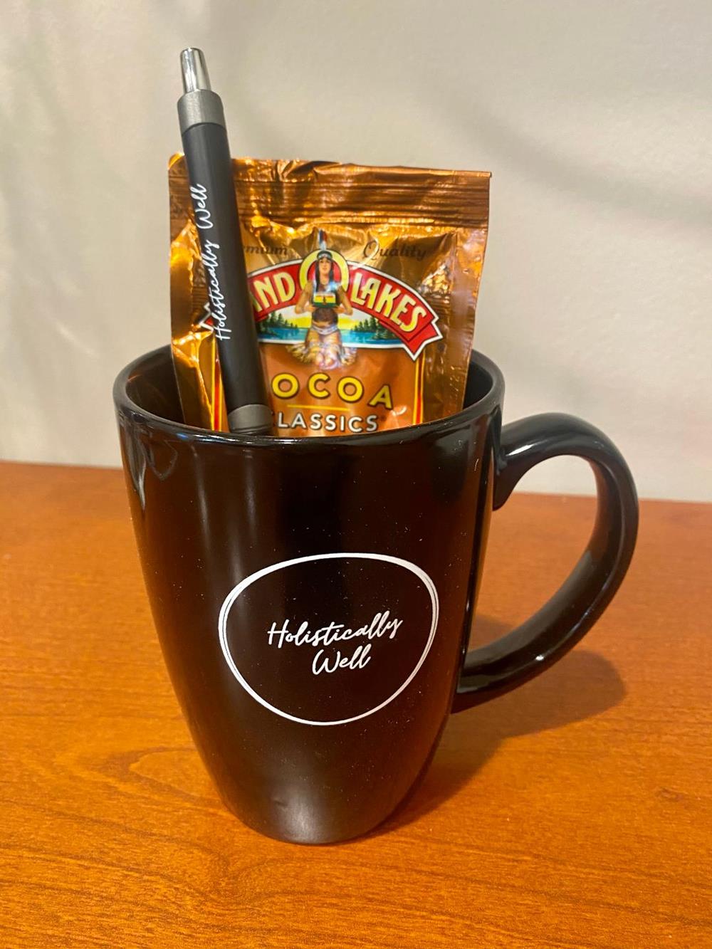 Customer photo from Barbara of our Challenger Grande Mug - Colors - 14 oz., a coffee mug with a pen and a packet of chocolate