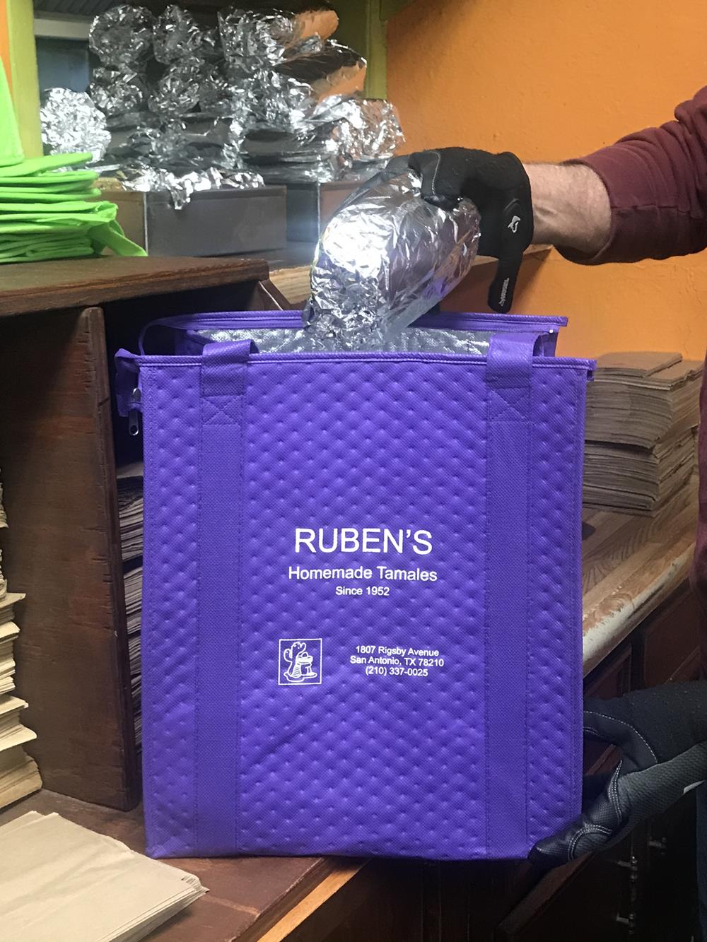 Customer photo from Sylvia of our Therm-O Tote Insulated Grocery Bag, a person putting foil in a purple bag