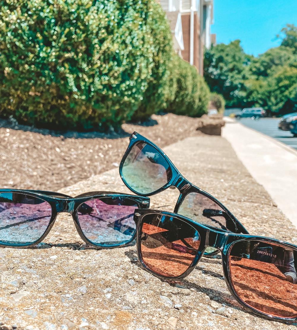Customer photo from Diane of our Risky Business Sunglasses - Gradient Lens, a group of sunglasses on a concrete surface