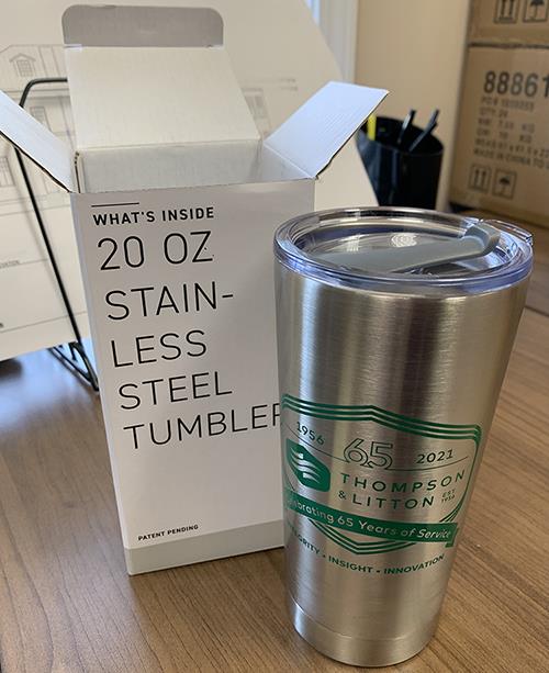 a stainless steel tumbler next to a box