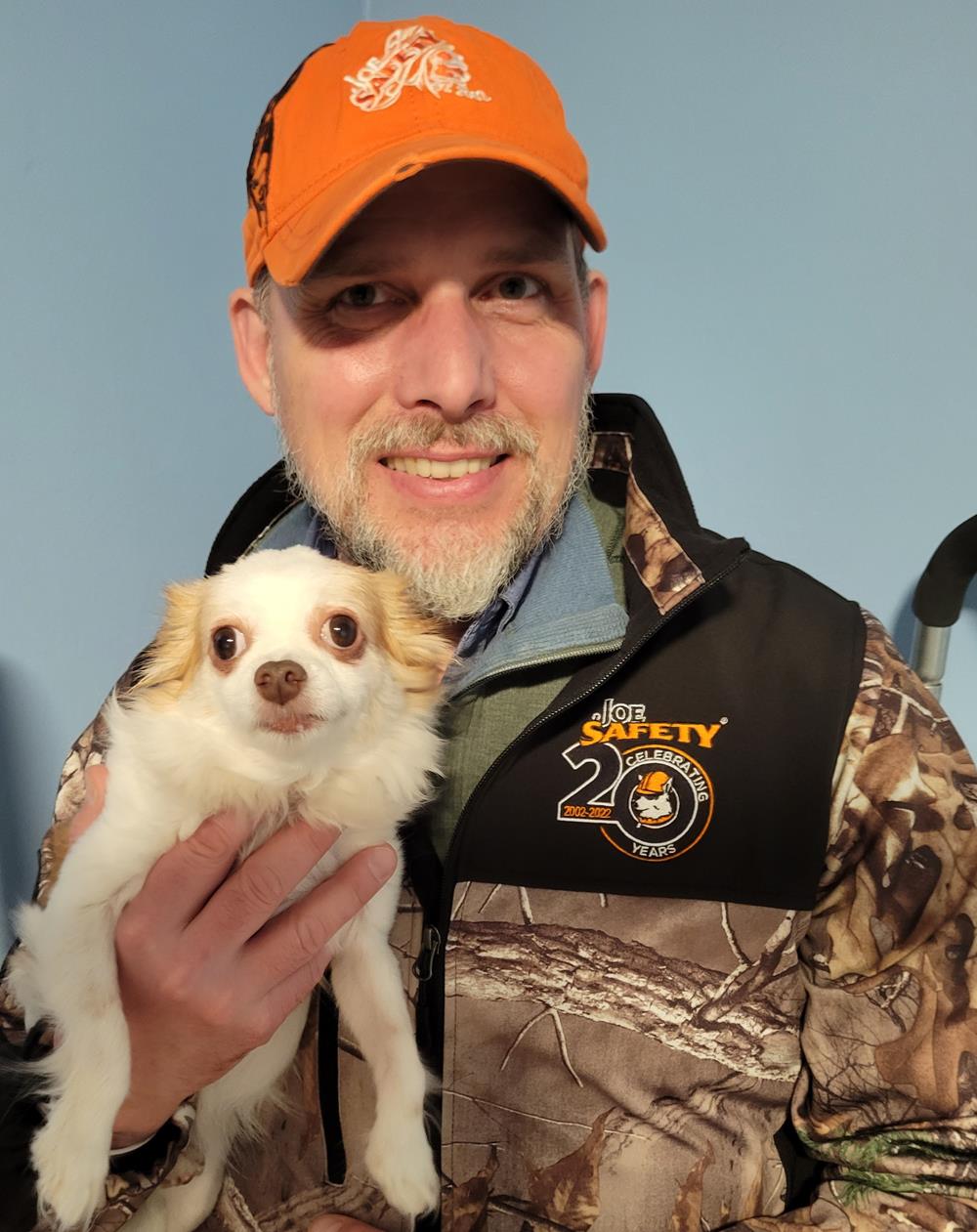 Customer photo from Amy of our Hunter Soft Shell Camo Jacket, a man holding a dog