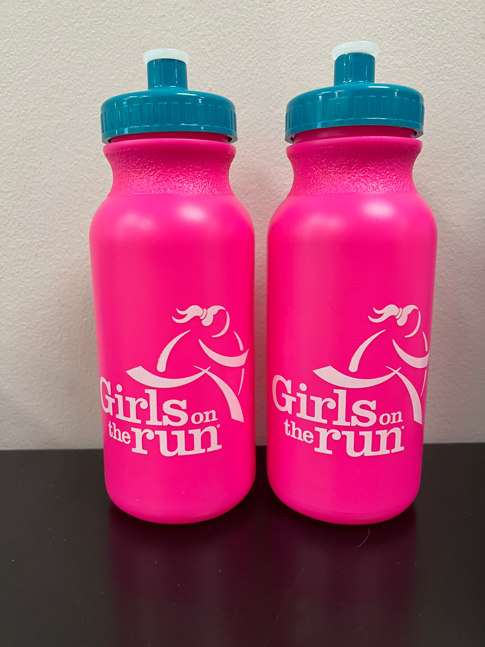 two pink water bottles with white text