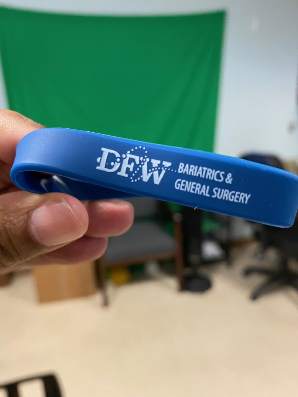 Customer photo from Sachin of our Printed Silicone Wristband, a hand holding a blue wristband