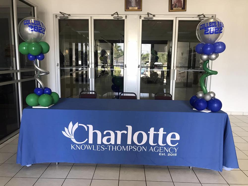 a table with balloons and a blue tablecloth in front of a door