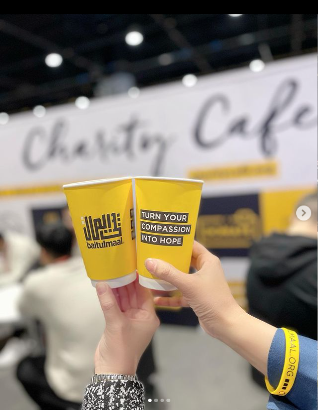 Customer photo from Khalid of our Full Color Insulated Paper Cup with Lid - 16 oz., a pair of hands holding two yellow cups