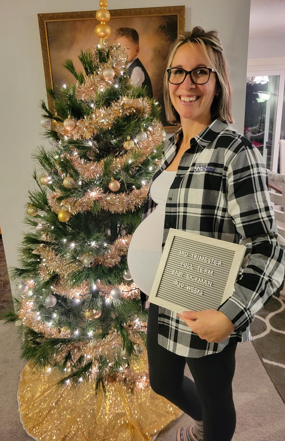 Customer photo from Matt of our Plaid Flannel Shirt - Men's, a woman holding a sign next to a christmas tree