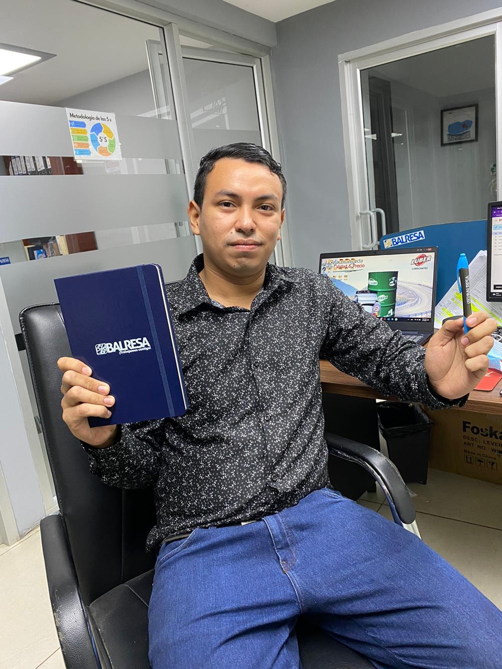 Customer photo from Balresa of our Ambassador Bound Journal Book - 8-3/8" x 5-1/2" - Screen, a man sitting in an office holding a book and pen