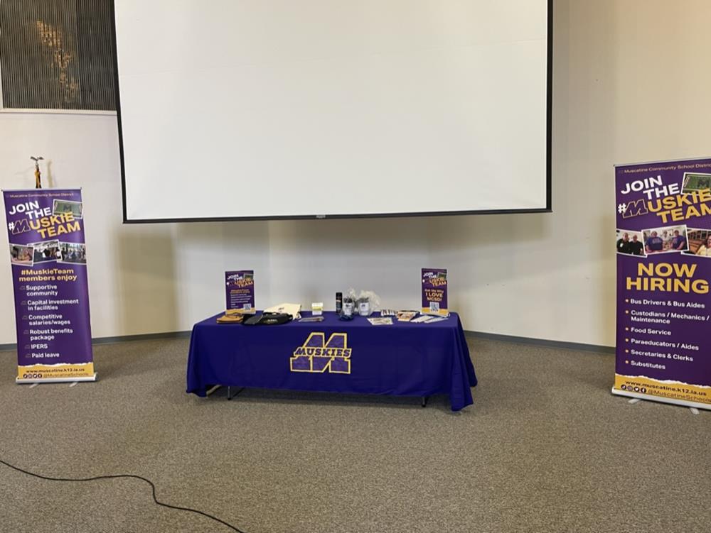 Customer photo from Jaime of our Value Polypropylene Retractable Banner Display - 31-1/2", a table with a blue cloth and a white screen