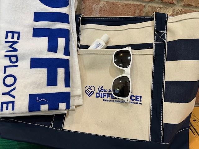 Customer photo from Elena of our Canvas Nautical 18 oz. Zip Top Tote - 14" x 24", a bag with sunglasses and a towel on it