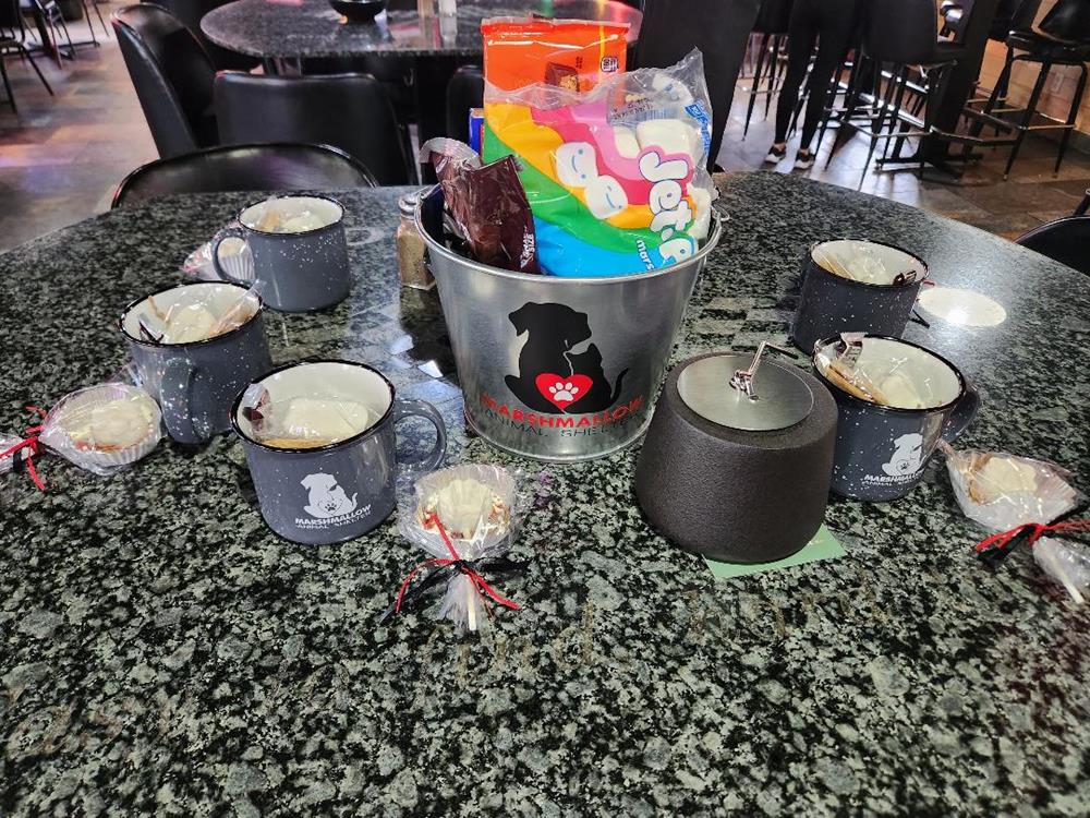 a group of cups and a bucket of candy on a table