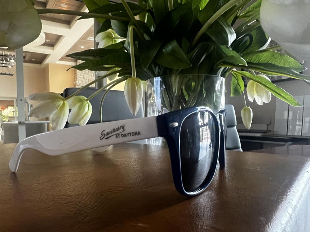 Customer photo from Zachary of our Colorblock Sunglasses - Full Color, a pair of sunglasses on a table with flowers