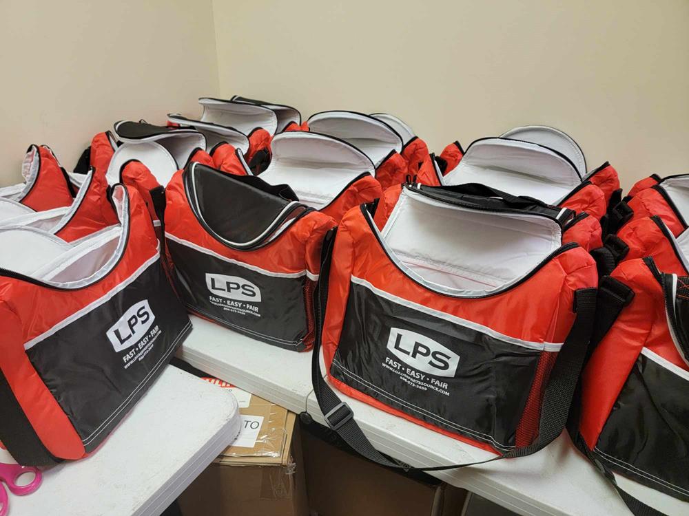 Customer photo from Jennifer of our Sightseeing 20-Can Event Cooler, a group of red and black bags