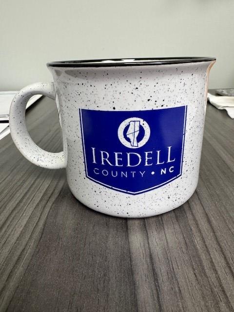 a white mug with a blue and white logo on it