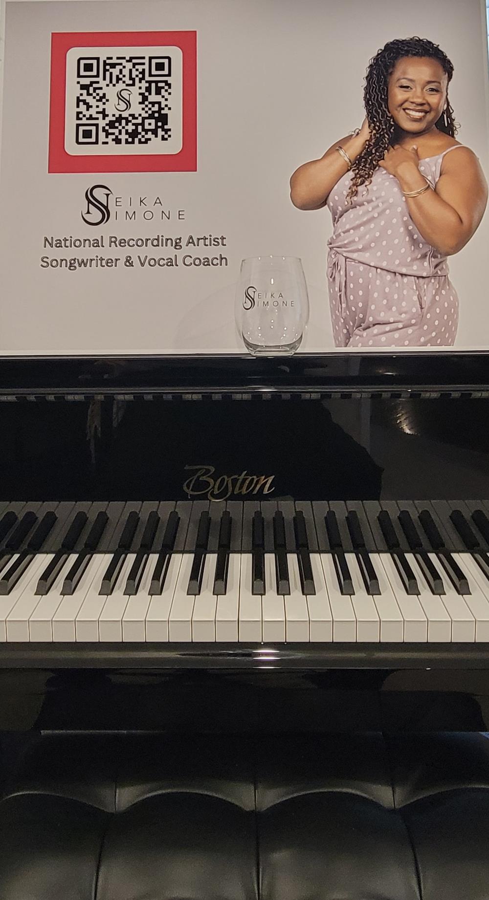 Customer photo from JD of our Sardinia Stemless Wine Glass - 15 oz., a poster on a piano