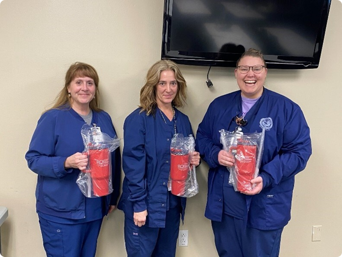Customer photo from Maeve of our Malibu Mug with Straw - 40 oz., a group of women wearing blue uniforms holding fire extinguishers