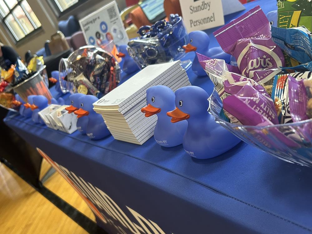Customer photo from Drew of our Color Changing Rubber Duck, a table with blue rubber ducks and a stack of candy