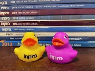 a pair of rubber ducks next to a stack of books