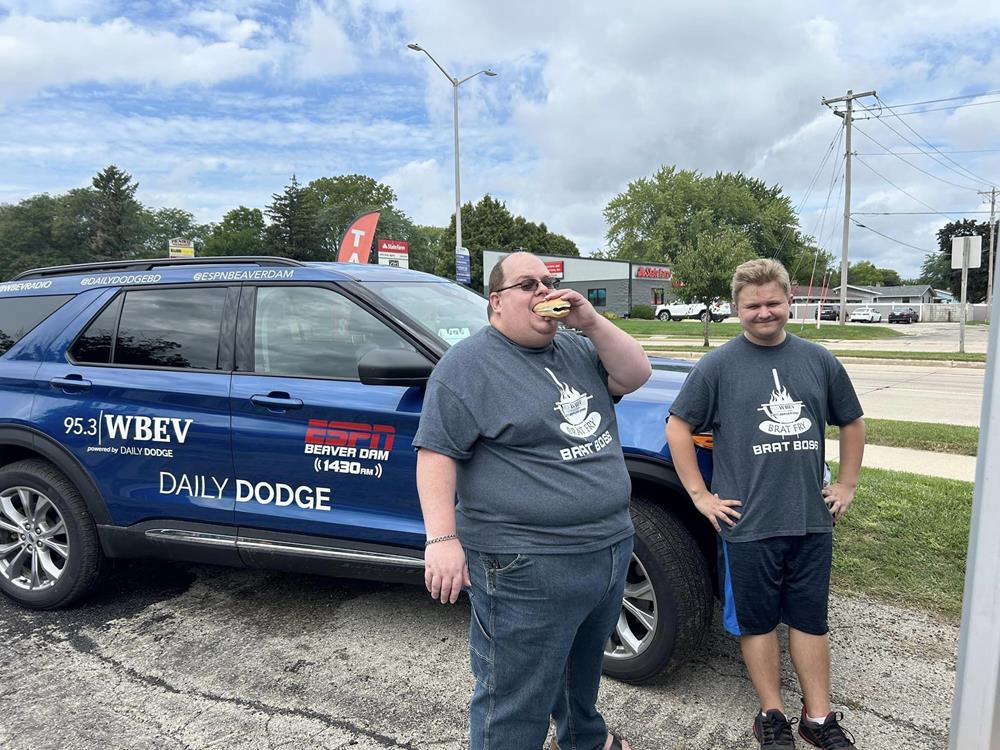 two men standing next to a car