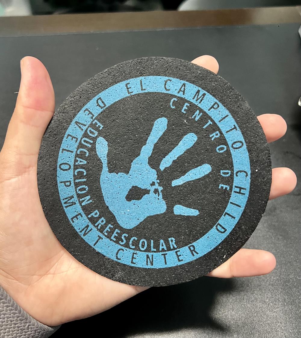 Customer photo from Aleyna of our Bic Clic Stic Pen, a hand holding a round black coaster with a blue handprint on it