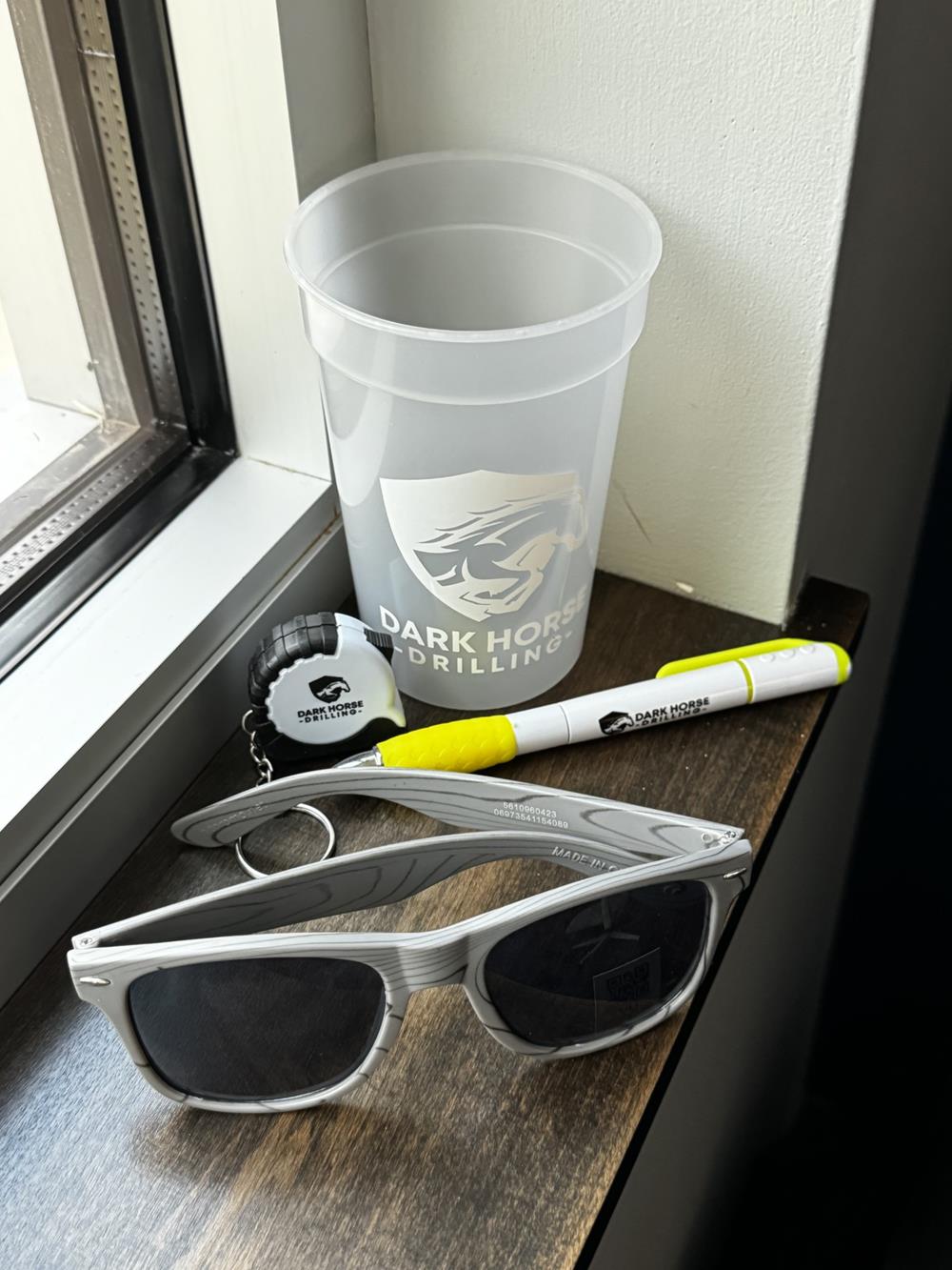 Customer photo from Rebekah of our Mini Grip Tape Measure, a pair of sunglasses and a pen next to a cup