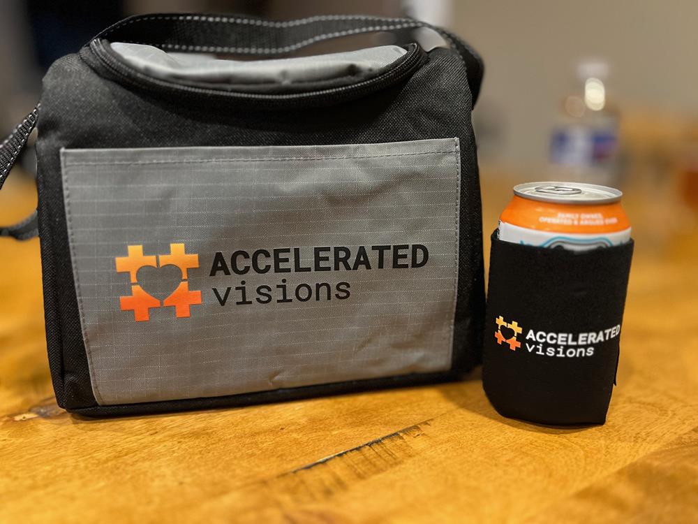 a black and grey bag with a beverage can on a wooden table