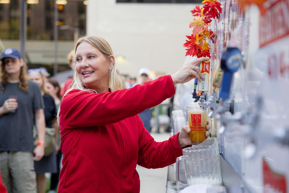 Customer photo from Isabelle of our Brew Pub Glass - 16 oz., a woman pouring a drink from a dispenser