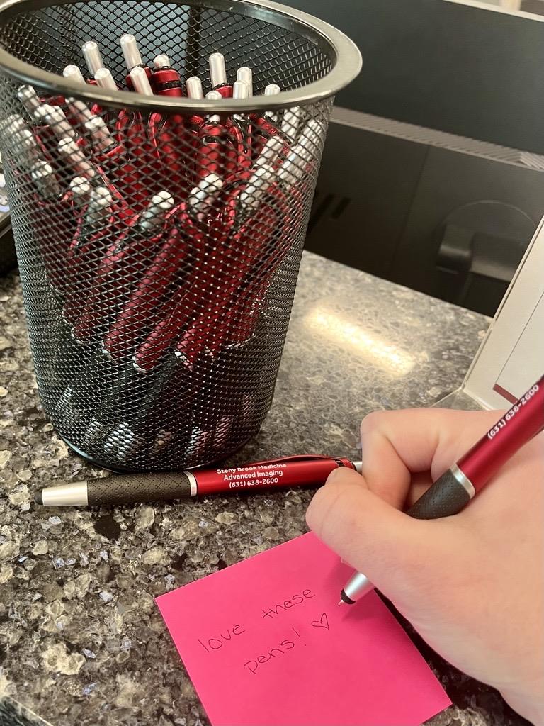 a hand writing on a post it note