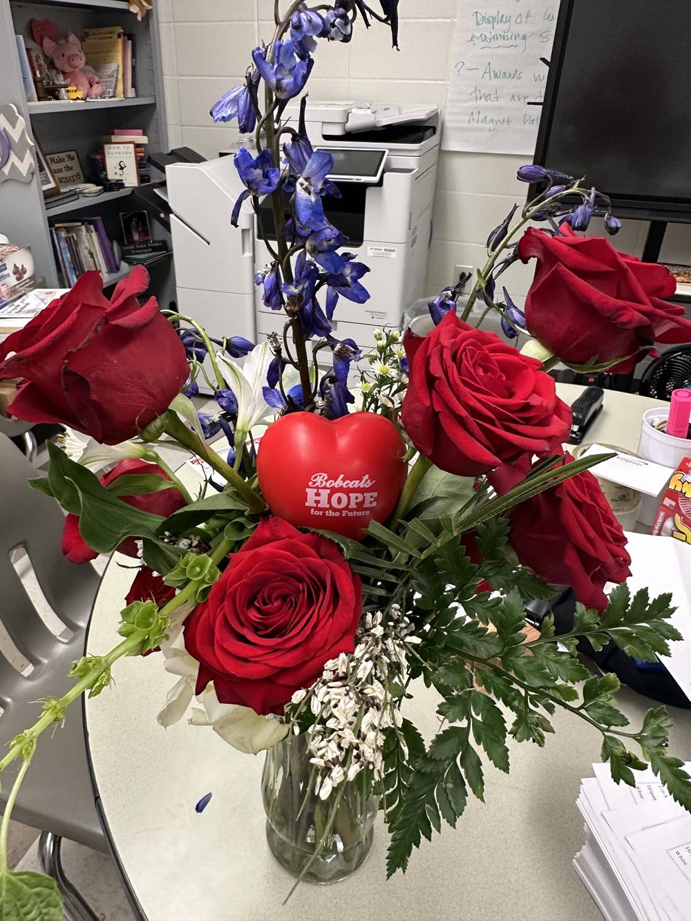Customer photo from Carol of our Heart Stress Reliever, a bouquet of red roses and blue flowers in a glass vase