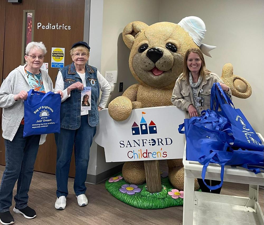 Customer photo from Alyce of our Value Polypropylene Tote, a group of women standing next to a stuffed bear