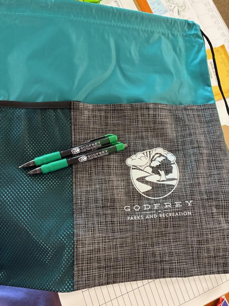 Customer photo from Jordan of our Etched Pocket Drawstring Sportpack, a group of pens on a bag