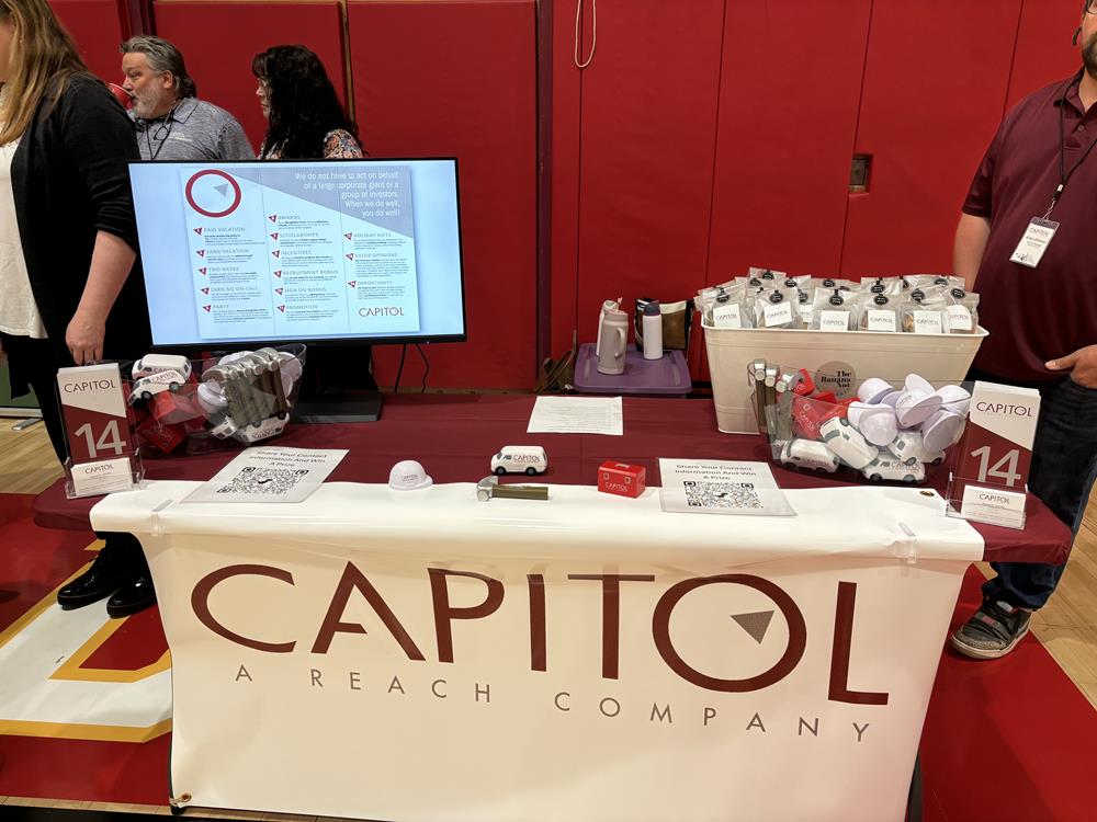 Customer photo from Nicole of our Hard Hat Stress Reliever - 24 hr, a table with a white banner and a red wall behind it