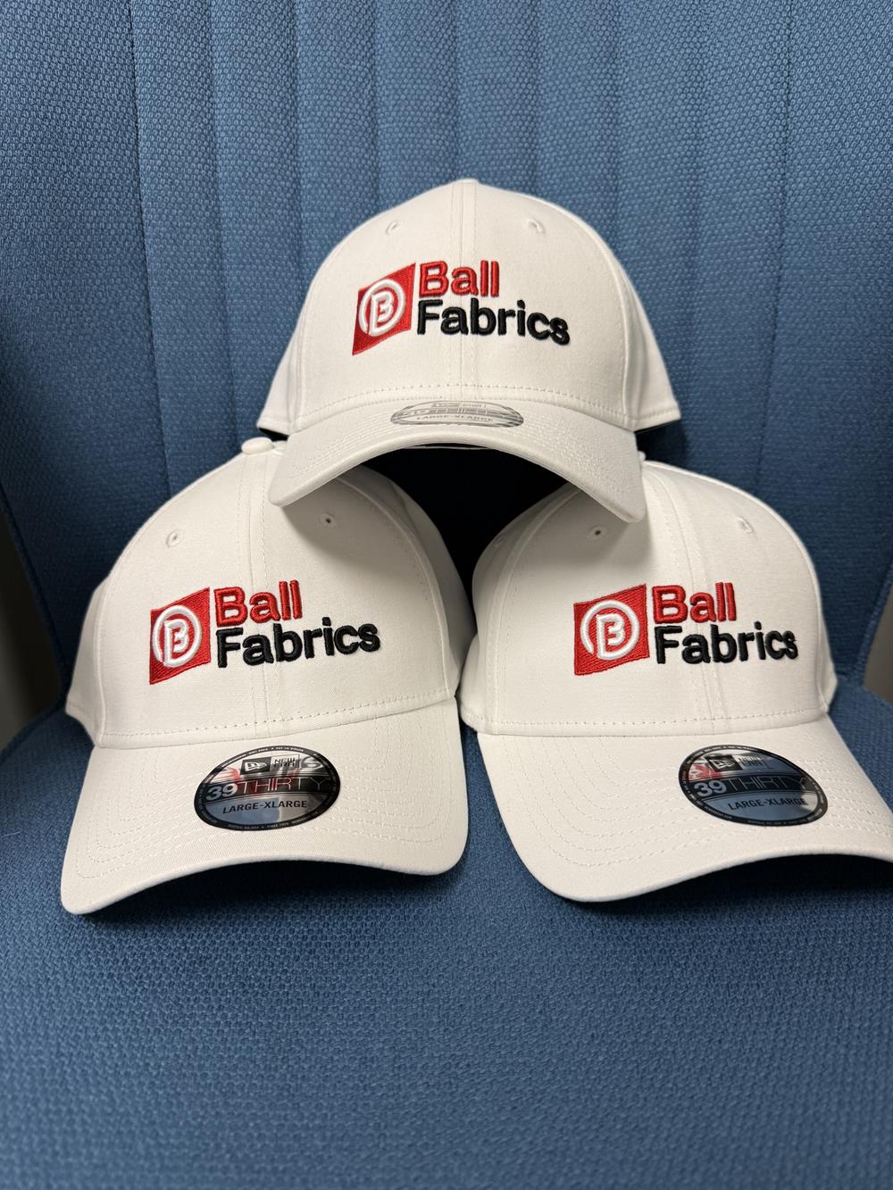 Customer photo from Ian of our New Era Structured Stretch Fit Cap - 3D Puff Embroidery, a group of white caps with black text on them