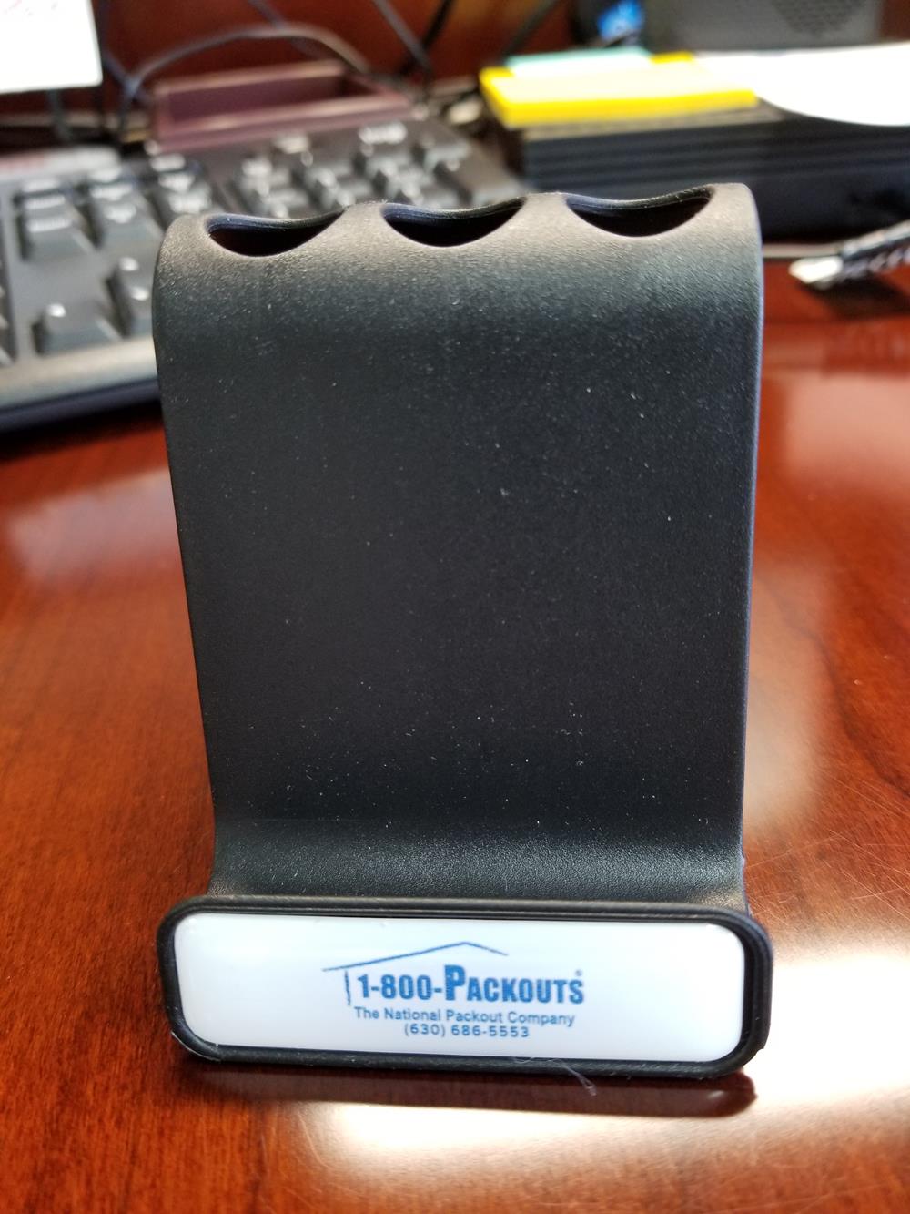 Customer photo from Penny of our Surf Phone Stand, a black object on a table